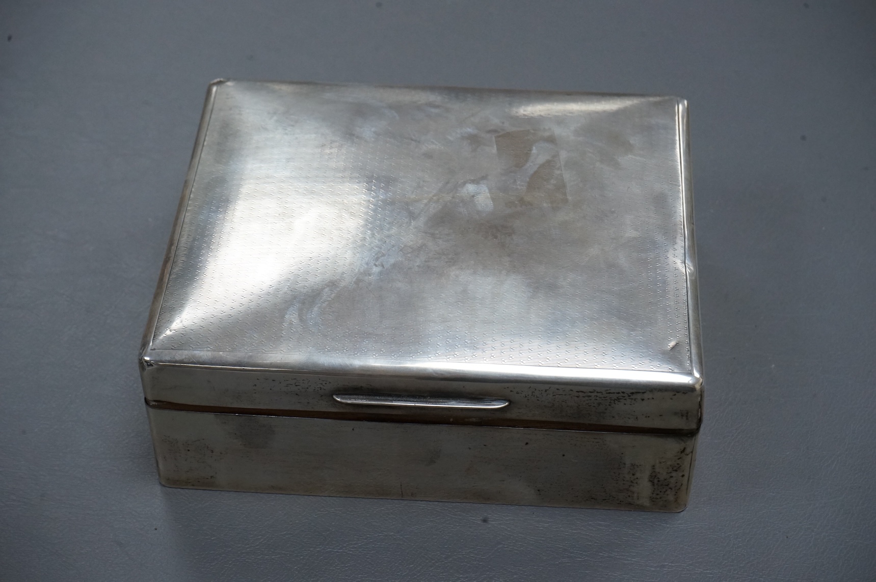 A George V silver mounted rectangular cigarette box, London, 1924, width 16cm, together with a smaller silver mounted cigarette box and a silver cigarette case.